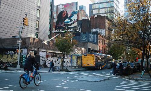 woman riding bike in back of new york mta hybrid bus