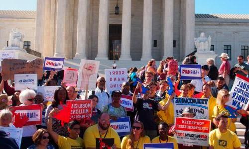 Protesters hold up anti-gerrymandering signs.